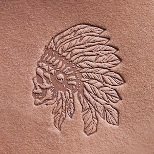 May include: A brown leather patch with an embossed design of a skull wearing a headdress with feathers.