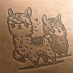 May include: A brown leather background with a line drawing of two alpacas. The alpaca on the left is larger and has a decorative pattern on its back. The alpaca on the right is smaller and has a simple design. Both alpacas have large eyes and a cute expression.