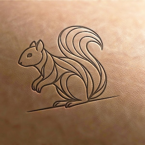 May include: A detailed, stylized illustration of a squirrel is embossed on a tan leather surface. The squirrel is depicted in a linear, geometric style with a large, curved tail. The design is a dark brown colour.