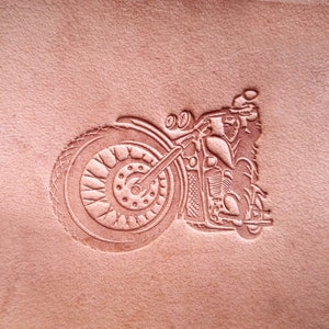 May include: A brown leather patch with a detailed embossed image of a motorcycle.