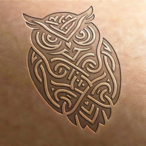 May include: An intricate design of an owl, created with a series of connected lines and curves, resembling a geometric pattern. The design is in a light brown colour and appears to be carved into a leather surface.