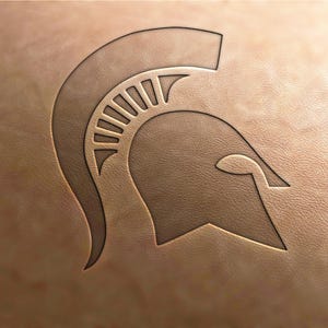 Può includere: Uno sfondo in pelle marrone con un contorno nero di un elmo spartano.