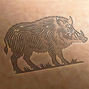 May include: A detailed line drawing of a wild boar, etched into a piece of brown leather. The boar is facing right and has a long snout and tusks.