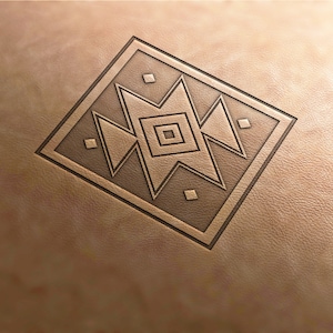May include: A brown leather background with a geometric design embossed in the centre. The design is a square with a central square and four triangles pointing outwards.