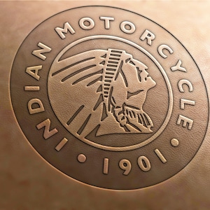 May include: A brown leather patch with an embossed Indian Motorcycle logo. The logo features an American Indian profile with a feathered headdress and the words "Indian Motorcycle 1901".