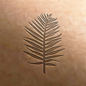 May include: A brown leather background with a carved palm leaf design.