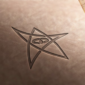 May include: A five-pointed star with a stylized eye in the center, embossed on a brown leather surface.
