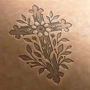Puede incluir: Una talla detallada de una cruz con acentos florales sobre una superficie de cuero marrón claro.