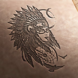 May include: A detailed, embossed leather design featuring a Native American woman in a feathered headdress. The artwork includes a dreamcatcher and birds, all in shades of brown and tan. The image is on a textured leather surface.