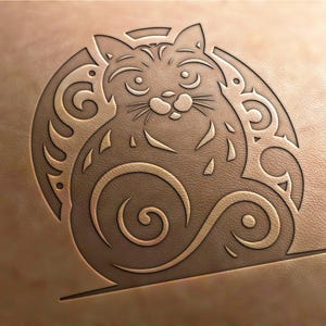 Könnte beinhalten: Ein brauner Lederhintergrund mit einer detaillierten, geschnitzten Abbildung einer Katze, die mit ihrem Schwanz um ihren Körper gewickelt sitzt. Die Katze ist von komplizierten Wirbeln und Mustern umgeben.