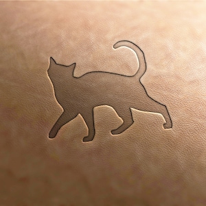 May include: A brown leather surface with a cutout silhouette of a cat.