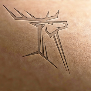 Peut inclure: Un dessin stylisé d'une tête de cerf avec des bois, gravé dans une surface en cuir brun clair.