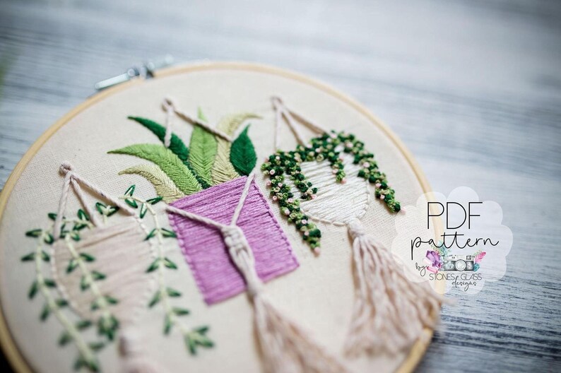 a close-up view of a hand-embroidered piece of art, showcasing intricate floral designs and patterns.