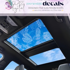 May include: A car sunroof featuring white tropical leaf decals applied to the glass, displaying a blue sky background. The text reads: STONES + GLASS digital, TROPICAL LEAVES {ANYWHERE} decals, DESIGNED FOR SUN/MOON ROOFS, BEAUTIFUL ANYWHERE YOU STICK THEM.
