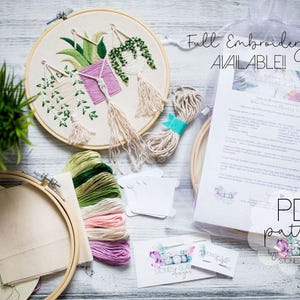 a variety of embroidery supplies, including a hoop, embroidery floss, and a pattern, arranged on a wooden surface.