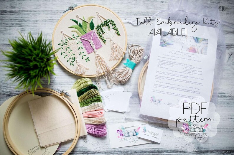 a variety of embroidery supplies, including a hoop, embroidery floss, and a pattern, arranged on a wooden surface.