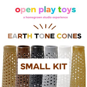 May include: A set of six conical objects with a perforated texture, arranged in a row. The colors include tan, brown, black, gray, white, and gold. Text above reads open play toys a homegrown studio experience and EARTH TONE CONES SMALL KIT.