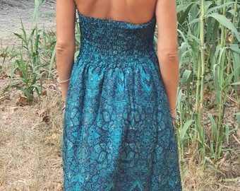 May include: A teal blue halter dress with a paisley pattern. The dress has a fitted bodice and a flowing skirt.