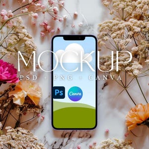 Op de afbeelding: Een paarse smartphone mockup met een blauwe lucht en een witte wolk op het scherm. De telefoon is omringd door roze en witte bloemen op een marmeren oppervlak. De tekst "MOCKUP" is in witte letters op de afbeelding geschreven. De tekst "PSD + PNG + CANVA" is in witte letters onder het woord "MOCKUP" geschreven. De logo's van Photoshop en Canva worden op het scherm weergegeven.