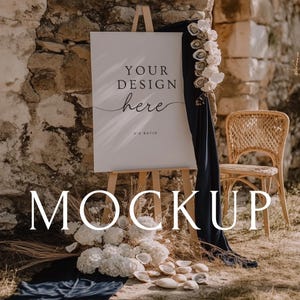 May include: A mockup sign on a wooden easel with the text "YOUR DESIGN here" and "3:4 RATIO". The sign is decorated with white flowers, seashells, and a navy blue drape. A wicker chair is in the background.