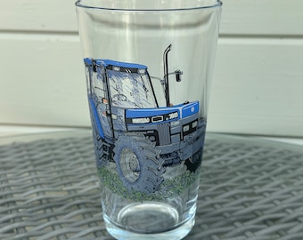 Könnte beinhalten: Ein klares Glas mit einem bedruckten Ford New Holland 7810 Traktor in Blau und Grau.