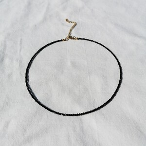 Puede incluir: Un delicado collar negro de choker hecho de peque&ntilde;as cuentas con un cierre dorado.