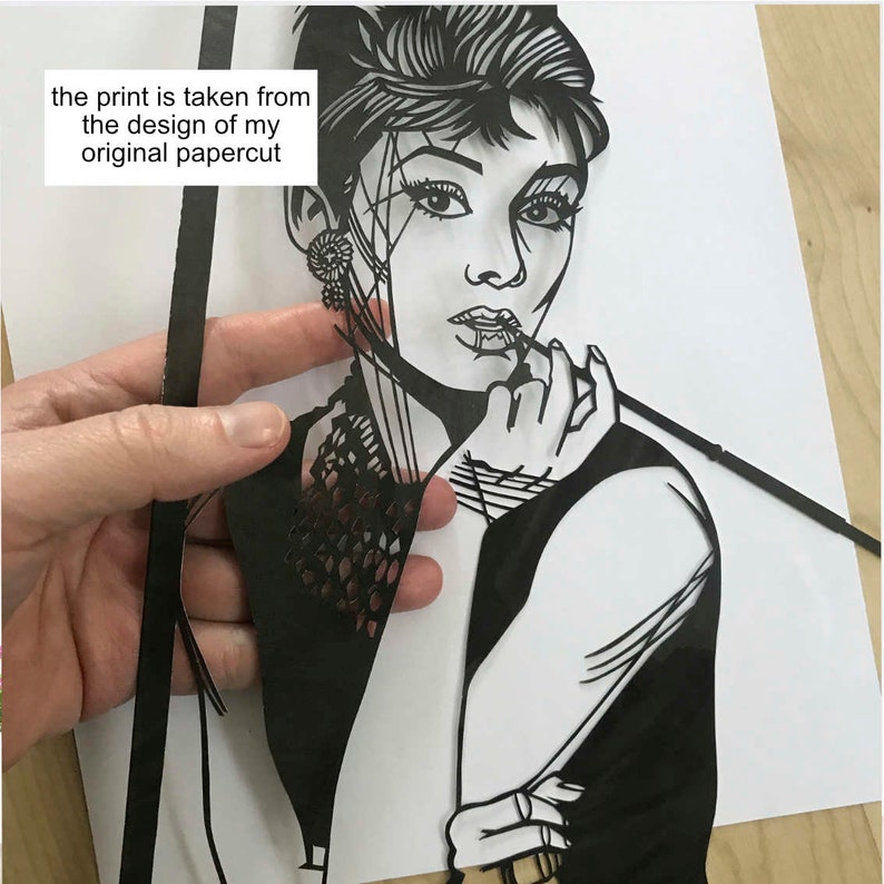 May include: Black and white papercut art of a woman with short hair, wearing a black dress and holding a cigarette. The text "the print is taken from the design of my original papercut" is visible in the image.