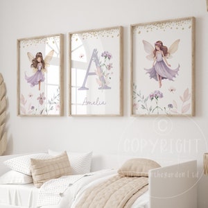 May include: Three framed prints with a watercolour fairy theme. The prints feature a fairy with wings, a letter A with flowers, and another fairy with wings. The prints have a white background with gold glitter accents and the name Amelia is written below the letter A.