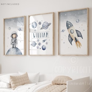 May include: Three framed watercolour prints with a space theme. The first print features an astronaut standing on the moon. The second print features planets and stars with the name "William". The third print features a rocket ship flying through space.
