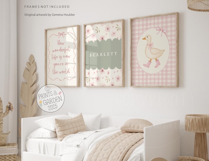 May include: Three framed prints with a nursery theme. One print has the text "How wonderful life is now you're in the world". Another has the name "SCARLETT". The third print features a duck wearing pink boots. All prints have a floral design.
