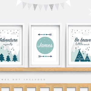 May include: Three framed prints with a woodland theme. The first print features a mountain range with trees and the text "Adventure awaits". The second print features a circle with the name "James" and arrows. The third print features a mountain range with teepees and the text "Be brave little one".