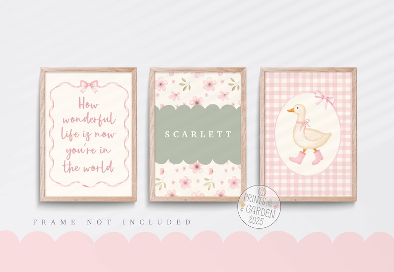 May include: Three framed art prints with a nursery theme. One print has the text "How wonderful life is now you're in the world". Another has the name "SCARLETT". The third print features a duck wearing boots. All prints have a pink and beige color scheme.