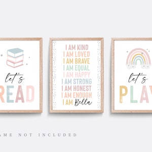 May include: Three printable wall art prints with a pastel colour scheme. The first print features a stack of books and the text "let's read". The second print features a rainbow and the text "let's play". The third print features the text "I am kind, I am loved, I am brave, I am equal, I am happy, I am strong, I am honest, I am enough, I am Bella".
