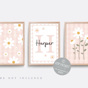 Könnte beinhalten: Drei rosa und weiße Gingham-Kinderzimmerdrucke mit weißen Gänseblümchen. Der mittlere Druck zeigt den Namen "Harper" in schwarzer Schrift mit einem großen rosa Buchstaben "H".