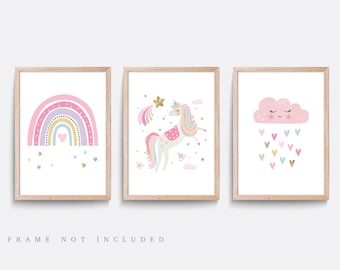 May include: Set of three pink and gold framed prints featuring a rainbow with stars, a unicorn with a rainbow tail and a cloud with hearts raining down.