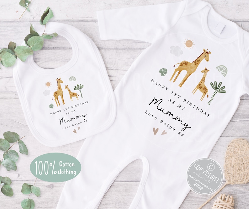 Op de afbeelding: Een witte romper en een slabbetje met een giraffenprint en de tekst "Happy 1st Birthday as my Mummy Love Ralph xx".
