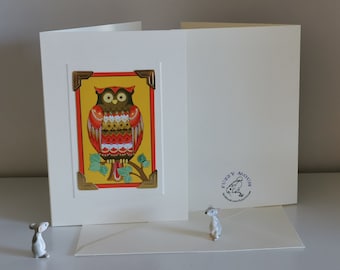 Op de afbeelding: Een witte kaart met een illustratie van een rode, gele en bruine uil in een gouden frame. De kaart heeft de tekst "Fuzzy Mouse" in paars in de rechterbenedenhoek.
