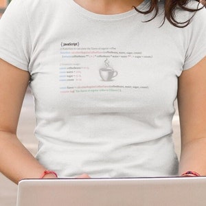 May include: A white t-shirt with a humorous graphic of JavaScript code that calculates the "flavor" of regular coffee. The code includes variables for coffee beans, water, sugar, and cream, and the result is a cup of coffee with steam rising from it.