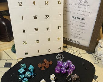 May include: A collection of dice sets, including D6, D12, and D20, in diverse colours and materials, arranged on a black felt surface. A calendar-style advent board with numbered slots is present, alongside a framed sign listing dice tray and bag options.