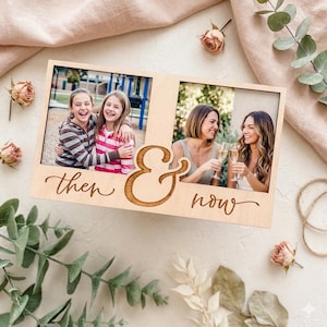 May include: A light-colored wooden photo frame with two rectangular openings. The left side shows two young girls, and the right side shows two women. The words "then & now" are engraved on the frame.
