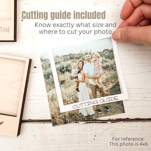 May include: A white photo frame with a family photo inside. The photo is of a family of four standing in a field. The frame has a white border and the words "Cutting Guide" printed on the bottom. The text "For reference: This photo is 4x6" is printed below the frame.