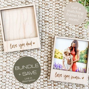 May include: Two wooden photo frames with a Polaroid style design. The frame on the left says "love you dad" and the frame on the right says "love you mom".