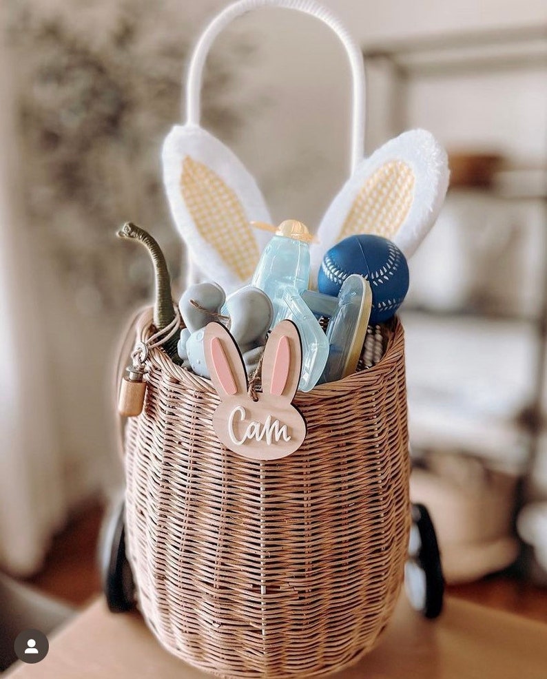 May include: A wicker basket with bunny ears, a wooden bunny tag with the name "Cam" and various toys inside.