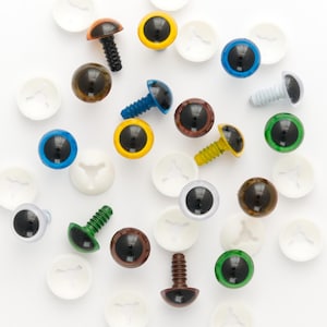 May include: Assortment of colorful plastic safety eyes with black pupils and screw backs. The eyes come in various sizes and colors, including blue, green, brown, and yellow. The eyes are packaged with white plastic washers.