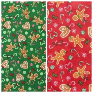 Può includere: Due campioni di tessuto con un motivo ripetuto di omini di pan di zenzero, bastoncini di zucchero, cuori e fiocchi. Un campione è verde con accenti bianchi e l'altro è rosso con accenti bianchi.