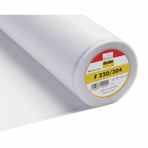 May include: A white roll of Vlieseline F 220/304 fusible interfacing for sewing. The label is yellow with black text and a red border. It says "FREUDENBERG" and "50% CV, 50% PES" and "90 cm x 25 m".