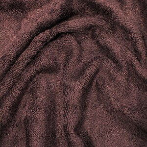 May include: Close-up of a soft, brown, plush fabric with a textured surface. The fabric is wrinkled and folded, creating a cozy and inviting look.