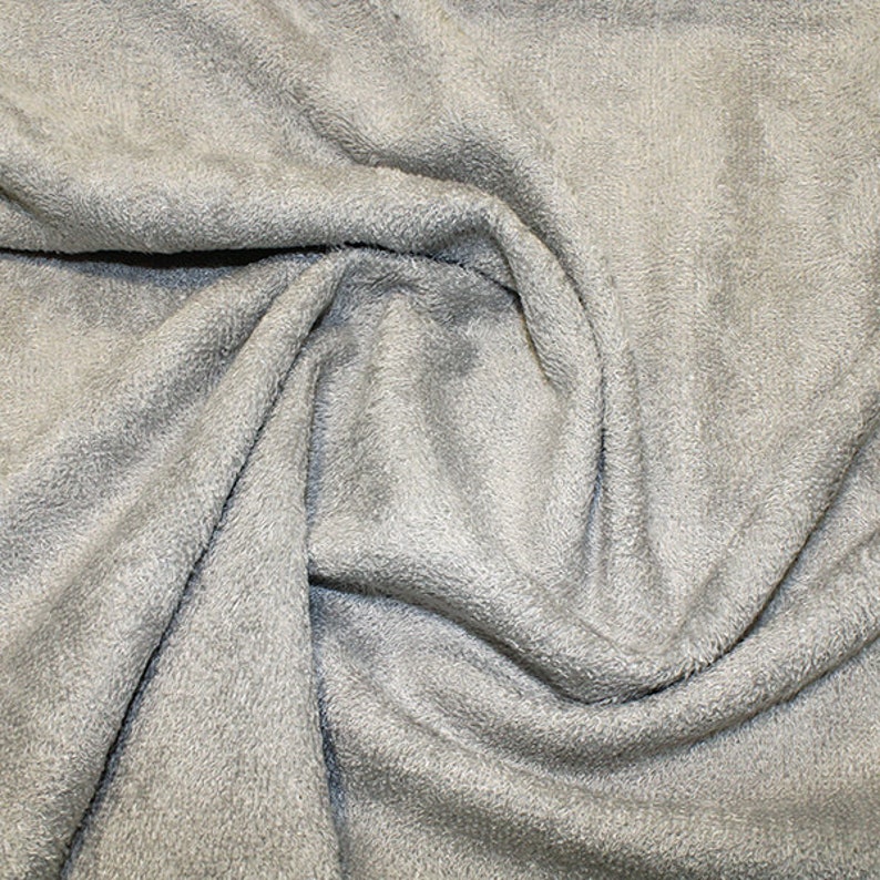 May include: A close-up of a soft, gray, textured fabric. The fabric is wrinkled and folded, showing its texture.