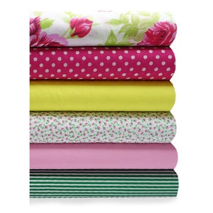 Puede incluir: Un rollo de tela de seis rollos en varios patrones. El rollo superior es blanco con rosas rosas, el segundo es rosa con lunares blancos, el tercero es amarillo, el cuarto es blanco con pequeñas flores rosas, el quinto es rosa y el último es verde con rayas blancas.