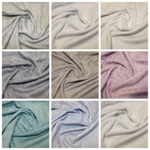 May include: A collection of nine fabric swatches in various colors, including white, gray, beige, pink, teal, and light blue. The fabric has a soft, textured, and fluffy appearance, similar to a towel.